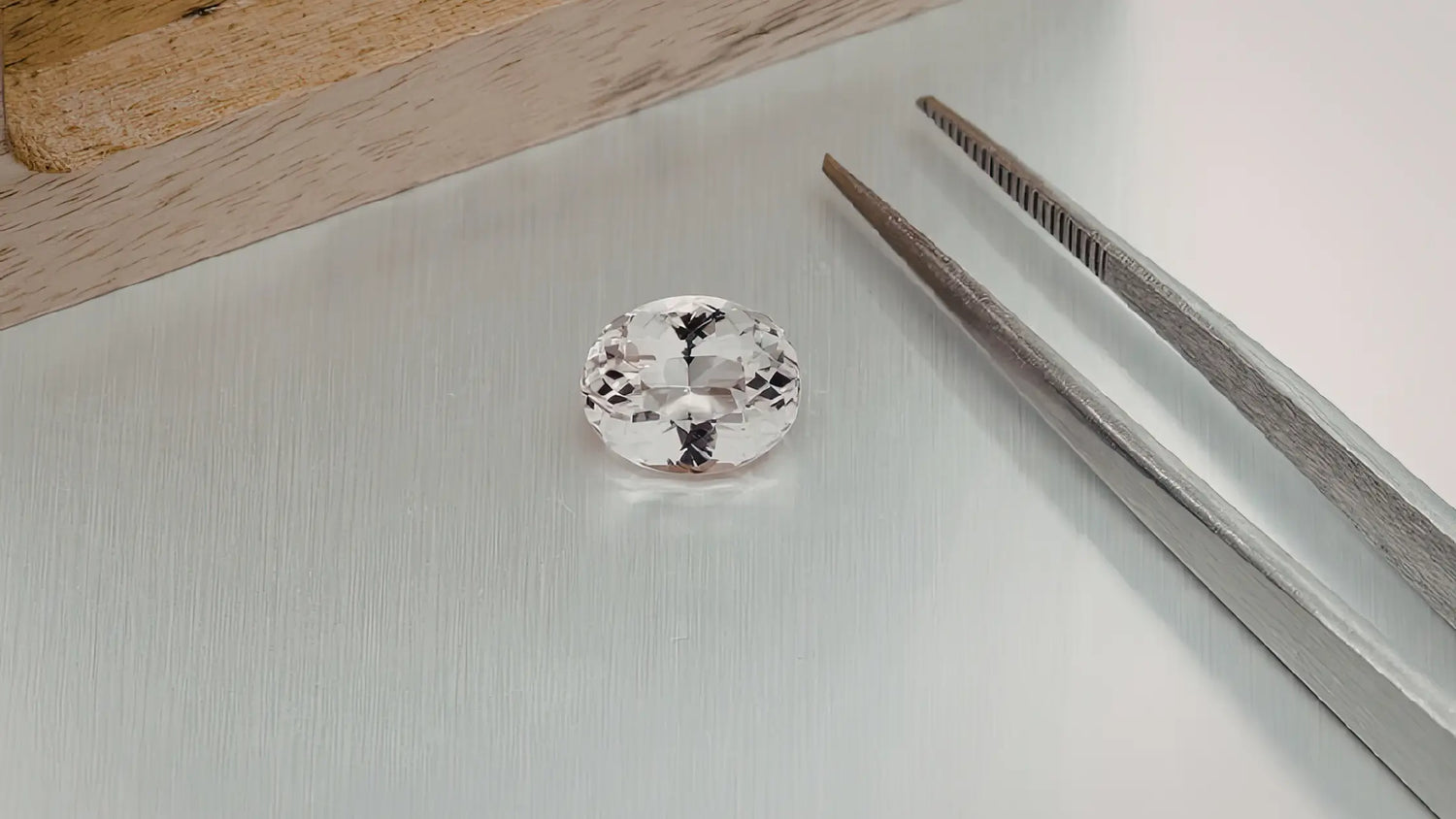 Diamond ring on a white surface with tweezers in Jupiter